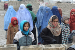 Girls and mothers, waiting for their duvets, in Kabul 