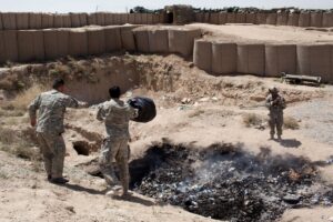 Two interpreters for Bravo troop dump their trash in the base’s burn pit in the Zhari District of Kandahar Province, April 2012. Photo: Sebastian Meyer/Corbis via Getty Images