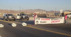 Die CodePink-Aktivisten Maggie Huntington und Toby Blomé blockieren am Freitag, dem 2. Oktober 2020, vorübergehend den Verkehr zur Creech Air Force Base in Nevada, wo unbemannte US-Luftdrohnenangriffe gestartet werden.
