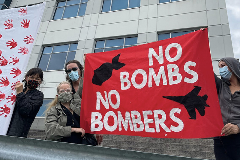 protesters with poster - no bombs no bombers