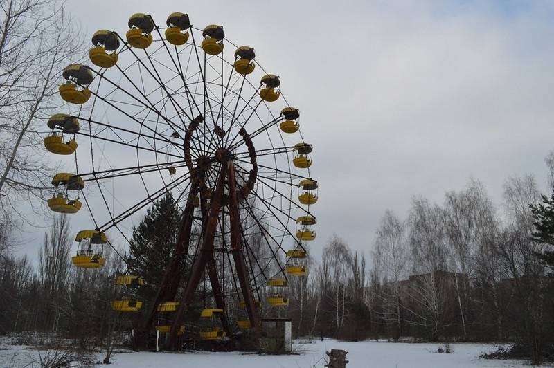 Grey-scale photograph of an abandoned ferris wheel destroyed in the Chernobyl disaster.